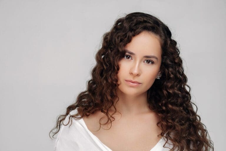 Bride in Montreal with natural curly hair, wearing minimal makeup, posing for a close-up shot